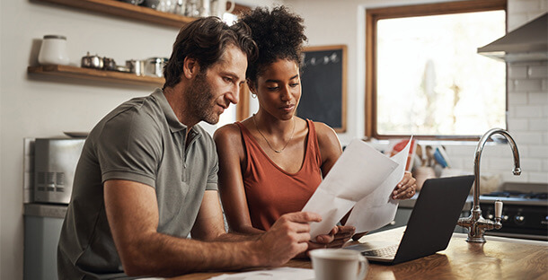 A couple review their finances in the kitchen.