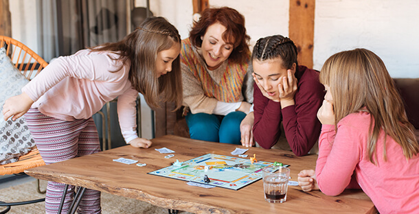 A family playing a board game on their coffee table.