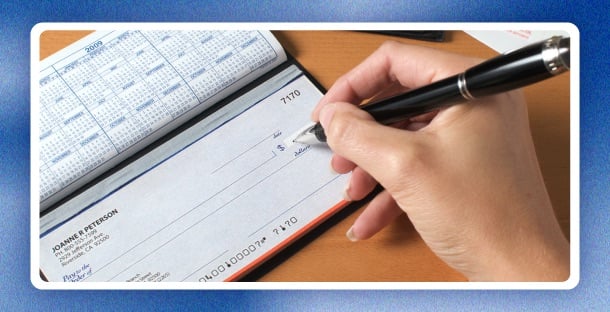 A person reviewing a paper check and bank statement