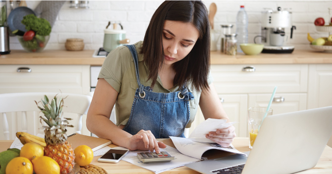 Woman sitting at a table reviewing her finances.