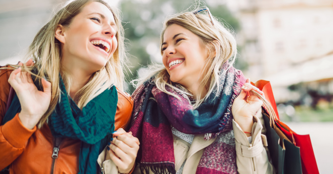 Two women in winter clothing laughing together
